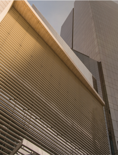 Low-angle view of modern skyscrapers in Latin America with louvered and glass facades under a clear sky.